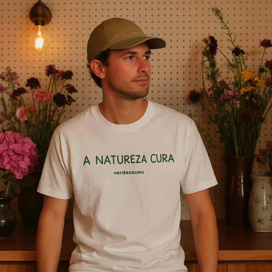 Camiseta branca em homem com boné verde com a escrita natureza cura